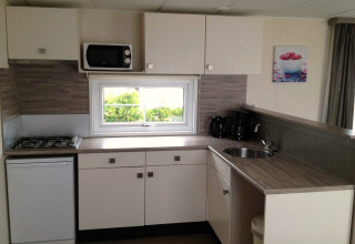 Moderne kitchenette in Berkel 6 glamping accommodatie met gasfornuis, magnetron en koffiezetapparaat.