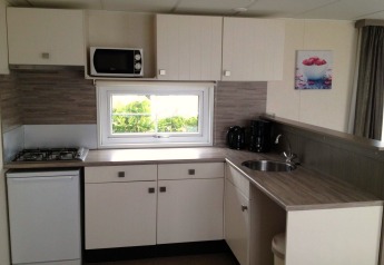 Moderne kitchenette in Berkel 6 glamping accommodatie met gasfornuis, magnetron en koffiezetapparaat.