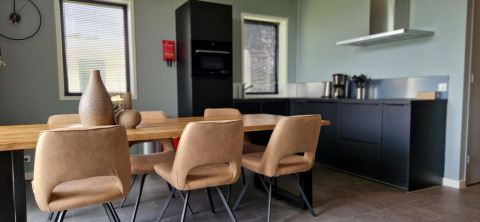 Cocina moderna y comedor en una tiny house de Marina Strandbad, Países Bajos, con mobiliario elegante.