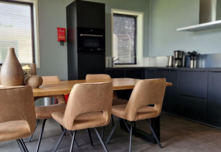 Cocina moderna y comedor en una tiny house de Marina Strandbad, Países Bajos, con mobiliario elegante.