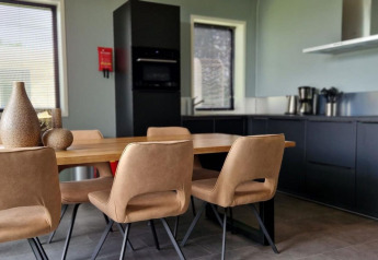 Cocina moderna y comedor en una tiny house de Marina Strandbad, Países Bajos, con mobiliario elegante.