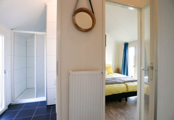 Interiør af Beach House 4 på Marina Strandbad i Holland, viser et soveværelse og et badeværelse.