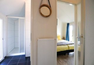 Vue intérieure du Beach House 4 à Marina Strandbad, Pays-Bas, montrant une chambre et une salle de bain.
