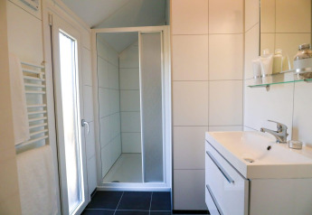 Moderne badkamer in Beach House 4 bij Marina Strandbad, Nederland, met douche, wastafel en spiegel.