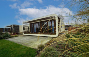 Modern Modus 4 lodge at Marina Strandbad, Netherlands, with unique rectangular design and natural setting.