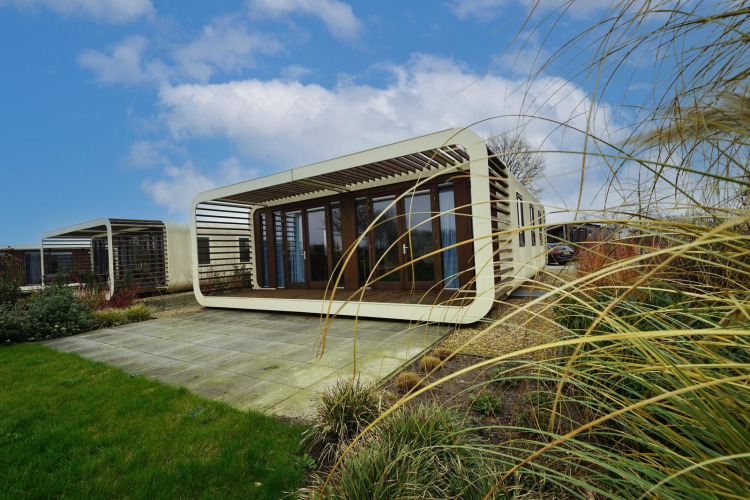 Moderne Modus 4 lodge bij Marina Strandbad, Nederland, met uniek rechthoekig ontwerp en natuurlijke omgeving.