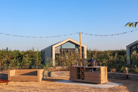 Un tiny house moderne nommé Tiny House 2 au Marina Strandbad aux Pays-Bas, avec espace extérieur aménagé.