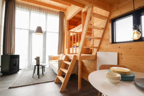 Interior moderno de Tiny House 4 en Marina Strandbad, Países Bajos, con diseño de madera y altillo.