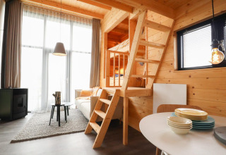 Modernes Interieur im Tiny House 4 im Marina Strandbad, Niederlande, mit Holzdesign und Hochbett.