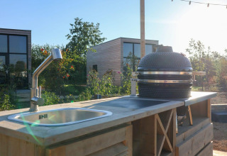 Buitenkeuken met spoelbak en barbecue bij Tiny House 4, Marina Strandbad, Nederland bij zonnig weer.