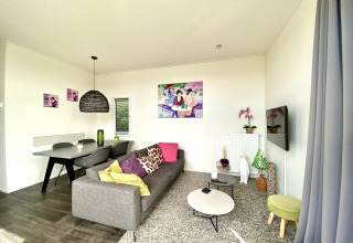 Lichte, moderne woonkamer in Cube la Mer 4 lodge bij Marina Strandbad, Nederland, met kleurrijke decoratie.