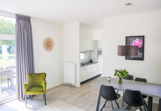 Lichte, moderne lodge Cube la Mer 4 bij Marina Strandbad in Nederland, met zit- en eethoek, eigentijdse stijl.