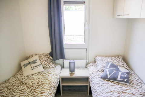 Dos camas individuales con ropa de cama animal print y cojines decorativos en Cube la Mer 4, Marina Strandbad.