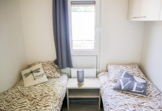 Deux lits simples avec housses à motif animalier et coussins décoratifs au Cube la Mer 4, Marina Strandbad.