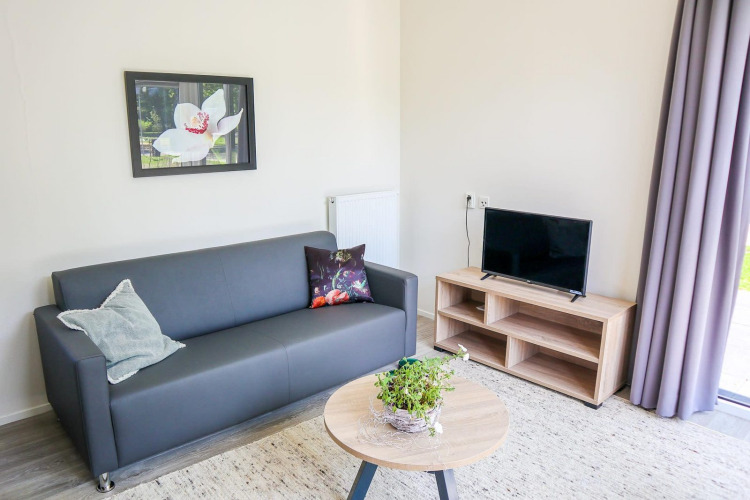 Acogedora sala de Cube la Mer 4 en Marina Strandbad, Países Bajos, con sofá, televisor y mesa.