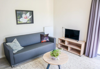 Moderne zithoek in Cube la Mer 4 aan Marina Strandbad, Nederland, met bank, tv en salontafel.