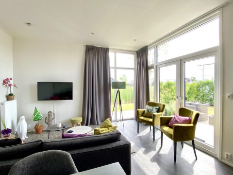 Moderne woonkamer met grote ramen en veel licht in Cube la Mer 4, Marina Strandbad, Nederland.
