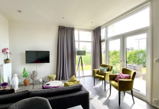 Lichte, moderne woonkamer met grote ramen in Cube la Mer 4, Marina Strandbad, Nederland.