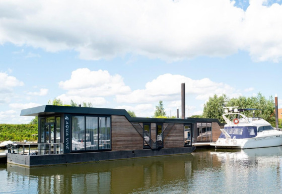 Casa flotante moderna Water lodge 4 atracada en Marina Strandbad, Países Bajos, en un día soleado.