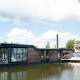 Et moderne husbåd kaldet Water lodge 4 ligger fortøjet ved Marina Strandbad i Holland på en solrig dag.
