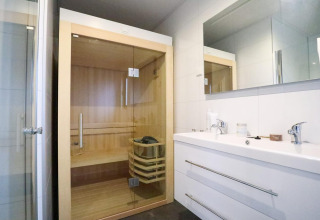 Baño moderno con sauna y lavabo doble en Wellness Lodge 2, Marina Strandbad en los Países Bajos.