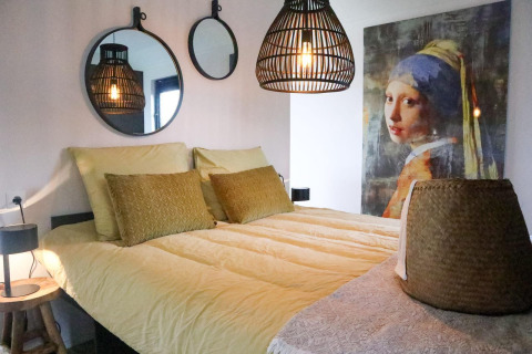 Camera da letto al Wellness Lodge 2 di Marina Strandbad nei Paesi Bassi con arredo moderno e opera d'arte famosa.