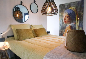 Dormitorio en Wellness Lodge 2, Marina Strandbad, Países Bajos, con decoración moderna y famosa obra de arte.