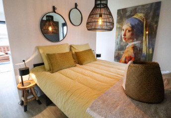 Moderne slaapkamer in Wellness Lodge 2, Marina Strandbad, Nederland, met stijlvolle inrichting en kunstwerk.