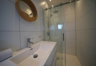 Modern badkamer in Modus 4 lodge bij Marina Strandbad, Nederland, met glazen douche en wastafel.