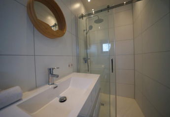 Moderne badeværelse i Modus 4-lodgen ved Marina Strandbad, Nederlandene, med brusekabine og vask.