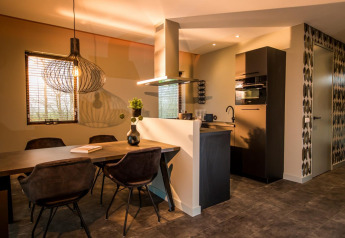 Modern lodge kitchen and dining area at Modus 4, Marina Strandbad, Netherlands, featuring stylish lighting.