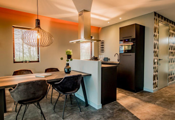 Modern dining and kitchen area in Modus 4 lodge at Marina Strandbad, Netherlands, featuring stylish decor.