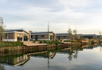 Modern lakeside lodges at Hackfort 6, De Kraaijenbergse Plassen in the Netherlands, with calm water reflections.