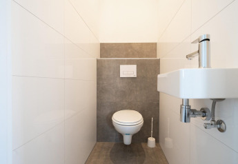 Minimalist restroom with wall-hung toilet and small sink, pictured at Hackfort 6, De Kraaijenbergse Plassen.