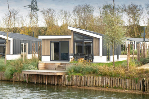 Lodge moderne en bord de l’eau à De Kraaijenbergse Plassen, Pays-Bas, avec terrasse et vue sur la nature.