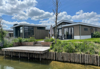 Photo of Hackfort 6 lodge at De Kraaijenbergse Plassen in the Netherlands, showing terrace and waterfront view.