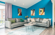 Sala luminosa en la cabaña Hackfort 8, De Kraaijenbergse Plassen, Países Bajos, con arte y muebles modernos.