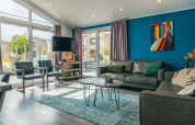 Salon contemporain du lodge Hackfort 8 à De Kraaijenbergse Plassen, Pays-Bas, avec déco moderne et grandes fenêtres.