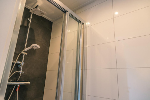 Moderne douchecabine met glazen deur en regendouche in Hackfort 8 in De Kraaijenbergse Plassen, Nederland.