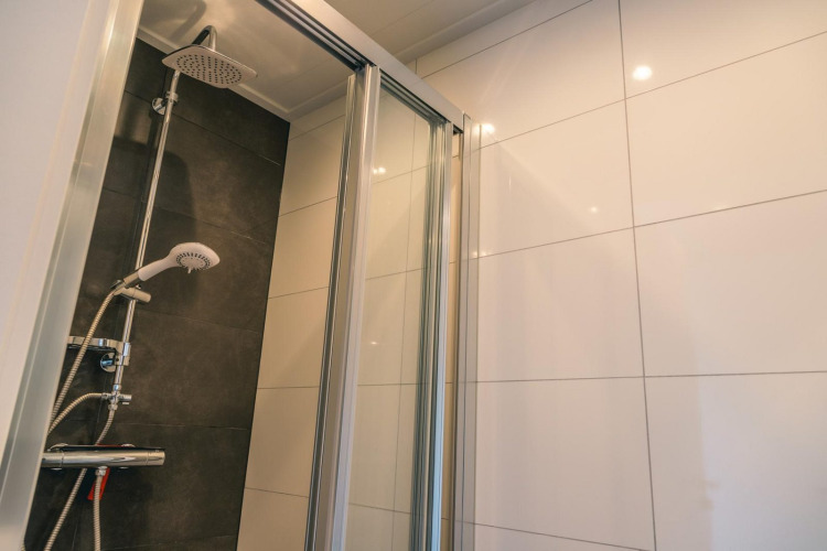 Cabina de ducha moderna con puerta de cristal y ducha tipo lluvia en Hackfort 8, De Kraaijenbergse Plassen, Países Bajos.