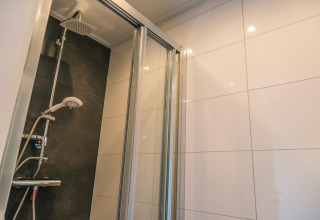 Moderne douchecabine met glazen deur en regendouche in Hackfort 8 in De Kraaijenbergse Plassen, Nederland.