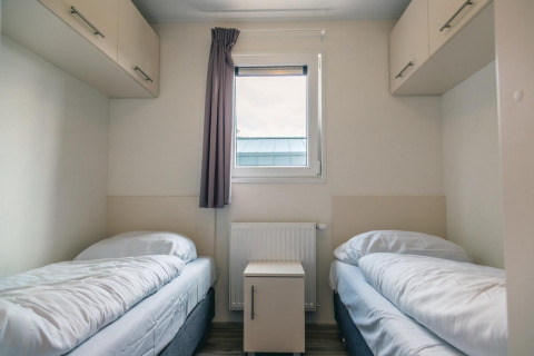 Chambre confortable au lodge Hackfort 8 à De Kraaijenbergse Plassen, Pays-Bas, avec deux lits simples.