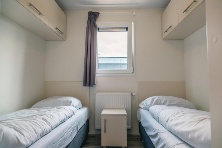 Acogedora habitación en el lodge Hackfort 8 en De Kraaijenbergse Plassen, Países Bajos, con dos camas.