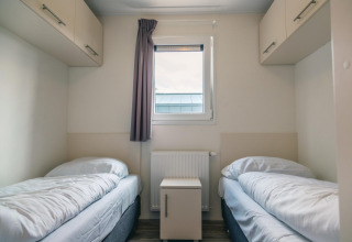 Chambre confortable au lodge Hackfort 8 à De Kraaijenbergse Plassen, Pays-Bas, avec deux lits simples.