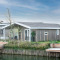 Lodge moderne en bois au bord de l'eau avec terrasse, situé à Hackfort Waterfront 4, vu depuis l'extérieur.
