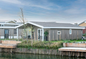 Lodge moderne en bois au bord de l'eau avec terrasse, situé à Hackfort Waterfront 4, vu depuis l'extérieur.