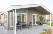 Moderna cabaña Hackfort Waterfront 4 con terraza y asientos al aire libre en De Kraaijenbergse Plassen, Países Bajos.