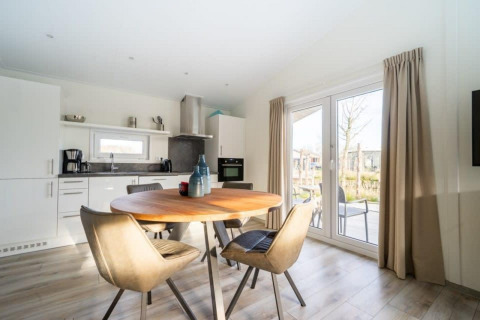 Zona de comedor y cocina moderna en la cabaña Hackfort Waterfront 4 en De Kraaijenbergse Plassen, Países Bajos.