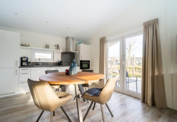 Moderne eet- en keukenruimte in Hackfort Waterfront 4 lodge bij De Kraaijenbergse Plassen, Nederland.