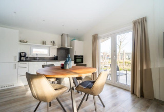 Zona de comedor y cocina moderna en la cabaña Hackfort Waterfront 4 en De Kraaijenbergse Plassen, Países Bajos.